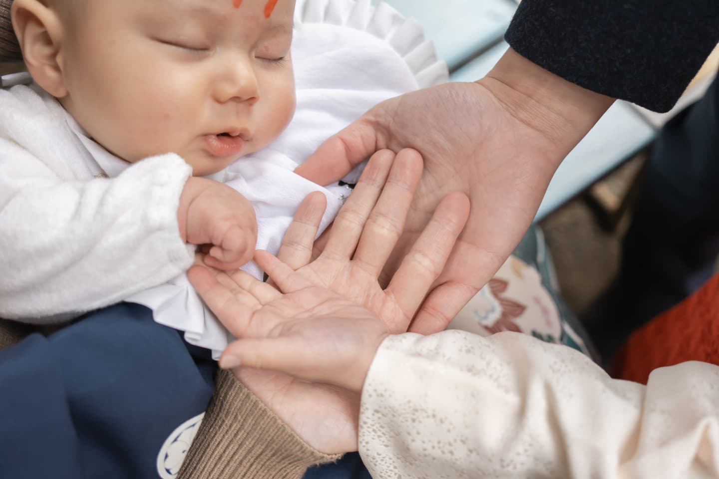 代々木八幡宮のお宮参りで家族に囲まれる赤ちゃんの写真