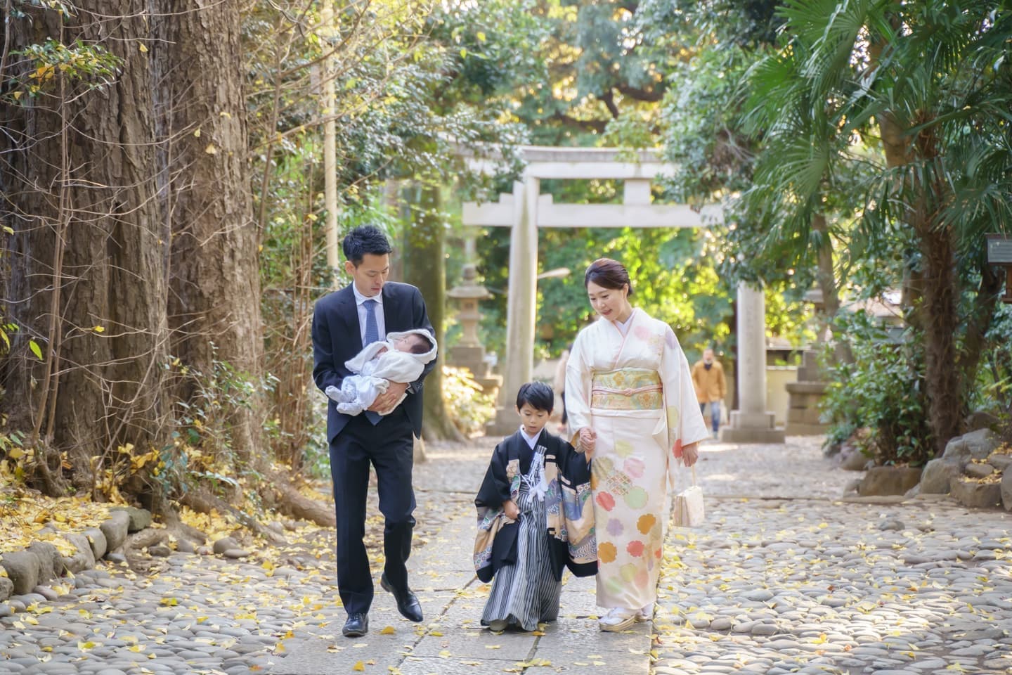代々木八幡宮のお宮参りで参道を歩くご家族の写真
