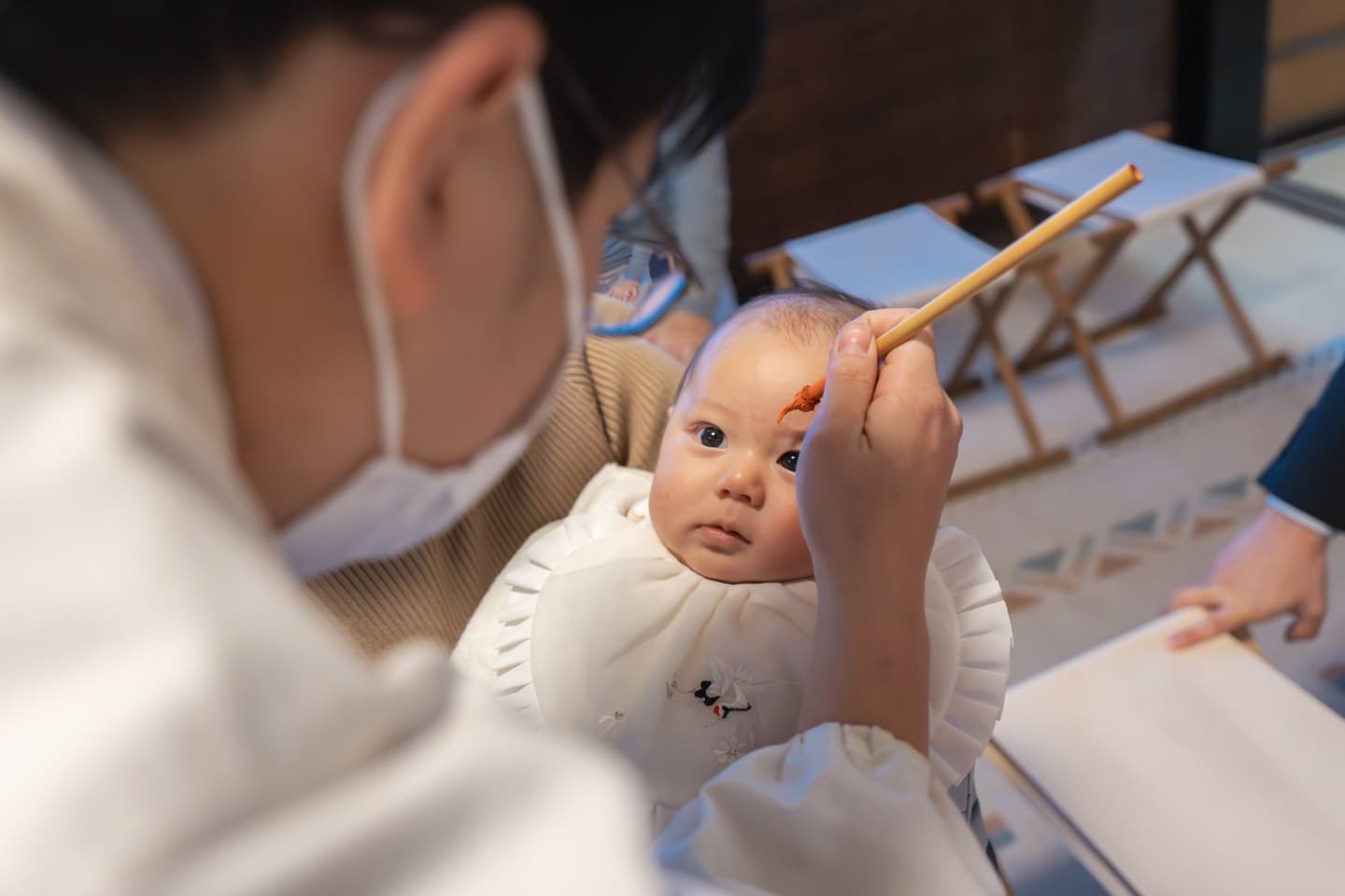 代々木八幡宮のお宮参りのご祈祷で魔除けの朱墨を塗っている赤ちゃんの写真